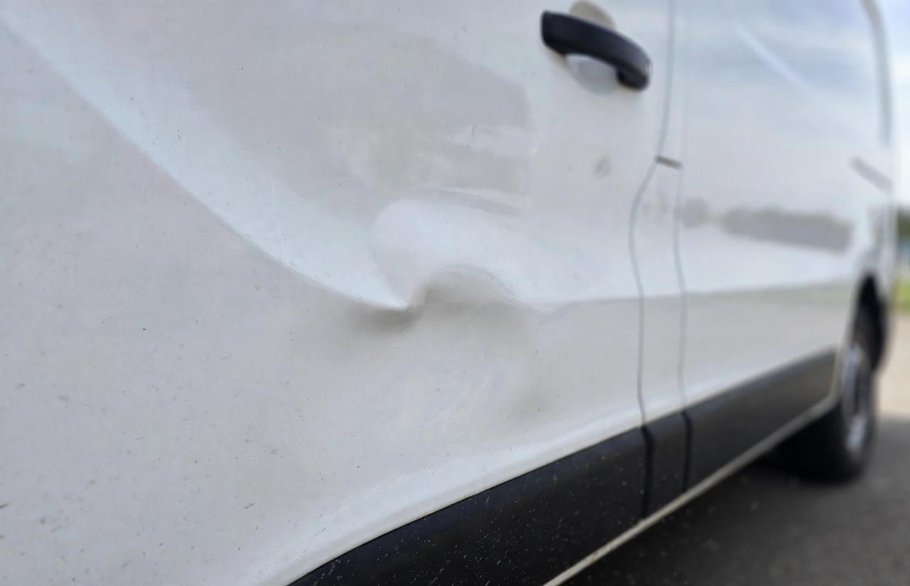 Fourgon utilitaire avant débosselage sans peinture, bosse importante sur le panneau latéral